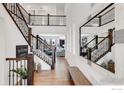 Grand foyer with soaring ceilings, hardwood floors, staircase, and a statement mirror at 117 Nova Ct, Erie, CO 80516