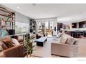 Bright living room with hardwood floors, stylish shelving and a sliding glass door to outdoor space at 117 Nova Ct, Erie, CO 80516