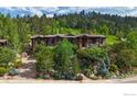 Beautiful multi-level home with mature trees and a stone driveway, set against a scenic backdrop at 1420 Sierra Dr, Boulder, CO 80302