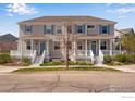 Two-story townhome features gray siding, blue shutters, and covered front porches at 1679 Saratoga Dr, Lafayette, CO 80026
