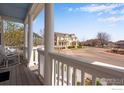 Inviting front porch with white columns and a seating area overlooking the street at 1679 Saratoga Dr, Lafayette, CO 80026