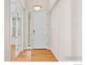 Bright foyer featuring hardwood floors, a white door, and a window allowing natural light at 22898 E Saratoga Pl, Aurora, CO 80015