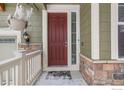 Inviting front door with sidelight, set in a stone and siding facade, under a covered porch at 22898 E Saratoga Pl, Aurora, CO 80015