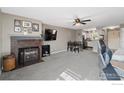 Inviting living area features carpet, fireplace, and ceiling fan, flowing into the kitchen for easy entertaining at 2660 E Otero Pl # 7, Centennial, CO 80122