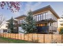 Modern townhome exterior with wood fence, balconies, and lush greenery, blending style with natural surroundings at 358 Arapahoe Ave # C, Boulder, CO 80302