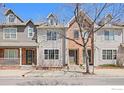 Inviting townhouse with a mix of brick and siding, complemented by a well-kept lawn and mature tree at 406 N Parkside Dr # C, Longmont, CO 80501