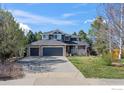 Charming two-story home with three-car garage, stone details, and a covered porch, set against a blue sky at 5397 Wild Dunes Ct, Boulder, CO 80301