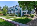 Charming row of townhouses with neatly manicured lawns, mature trees, and inviting front porches with a balcony at 658 Casper Dr, Lafayette, CO 80026