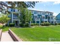 Attractive townhouse row featuring lush green lawns, mature trees, and inviting front porches with balconies at 658 Casper Dr, Lafayette, CO 80026