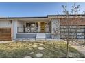Charming front porch with a bright yellow door and updated railings at 7750 W 9Th Ave, Lakewood, CO 80214