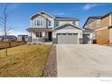 Charming two-story home with a three-car garage, landscaped front yard, and stone accents at 806 Flora View Dr, Erie, CO 80516