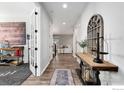 Welcoming entry hall featuring hardwood floors and stylish décor, opening to the living area at 806 Flora View Dr, Erie, CO 80516
