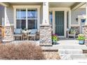 Inviting front porch with decorative stone columns and comfortable seating creating a welcoming entrance to the home at 878 Wagon Bend Rd, Berthoud, CO 80513