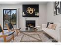 Stylish living room features a modern fireplace, elegant furniture, and a walk-out to a balcony at 9680 Brentwood Way # 203, Broomfield, CO 80021