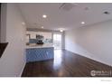 Bright and airy kitchen featuring modern appliances, a stylish island, and seamless access to the living area at 10591 Forester Pl, Longmont, CO 80504
