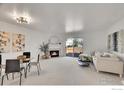 Bright living room features a fireplace and access to the outdoor deck at 1202 Warrior Way, Lafayette, CO 80026