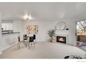 Open living room with dining area adjacent to the kitchen and fireplace at 1202 Warrior Way, Lafayette, CO 80026