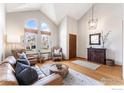 Inviting living room featuring vaulted ceilings, hardwood floors, and large windows offering plenty of sunlight at 13080 W 61St Cir, Arvada, CO 80004
