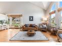 Bright living room with vaulted ceilings, hardwood floors, and large windows that let in plenty of natural light at 13080 W 61St Cir, Arvada, CO 80004