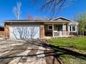 Home exterior with brick accents, lush lawn, and a two car garage on a sunny day at 1406 Oak Dr, Berthoud, CO 80513