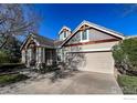 A well-maintained home with a neutral color palette, an attached two-car garage, and mature shrubs at 1430 Bluefield Ave, Longmont, CO 80504