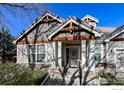 Inviting front entrance with stone accents, white pillars, and an decorative security door at 1430 Bluefield Ave, Longmont, CO 80504