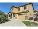 Charming two-story home with a covered porch and a two-car garage, set against a clear blue sky at 1512 Lasalle Way, Longmont, CO 80504