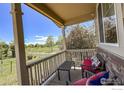 Inviting front porch with comfortable seating and views of the green lawn and open space at 1512 Lasalle Way, Longmont, CO 80504