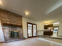 Cozy living room with a brick fireplace, staircase, and opening into the kitchen at 1525 Peterson Pl, Longmont, CO 80501