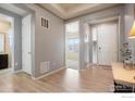 Bright foyer featuring light hardwood flooring, leading to other rooms in the home at 16024 Columbine St, Thornton, CO 80602