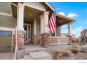 Inviting front porch adorned with stone accents, offering a warm welcome to the home at 16024 Columbine St, Thornton, CO 80602