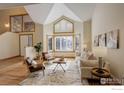 Comfortable living room with vaulted ceilings, hardwood floors, and an adjacent entryway at 2215 Spotswood Pl, Boulder, CO 80304