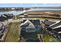 Aerial view of a light gray home with dark roof tiles near a lake community at 2774 Heron Lakes Pkwy, Berthoud, CO 80513