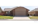 Attractive home with a spacious driveway leading to an attached garage and green lawn at 3401 Mountain View Ave, Longmont, CO 80503