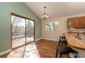 Eat-in kitchen features wood cabinets, breakfast bar with seating and a sliding glass door to the deck at 373 Fir Ln, Broomfield, CO 80020