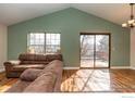 Spacious living room boasts vaulted ceilings, a sliding glass door and a large window for natural light at 373 Fir Ln, Broomfield, CO 80020