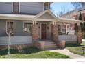 Charming covered front porch with brick pillars, a red door, and ample space for outdoor seating at 436 Pratt St, Longmont, CO 80501
