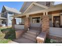Inviting front porch featuring brick pillars and a cozy porch swing, perfect for relaxing outdoors at 436 Pratt St, Longmont, CO 80501