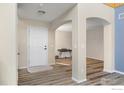 Bright foyer with hardwood floors and archways that opens to other rooms in the home at 5209 Royal Pine St, Brighton, CO 80601