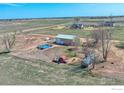 Aerial view of a property with an above-ground pool, a barn, multiple homes, and vast open land at 6251 County Road 20, Longmont, CO 80504