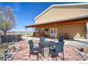 Covered patio featuring a hot tub and fire pit table with comfortable chairs, perfect for outdoor entertainment at 6251 County Road 20, Longmont, CO 80504