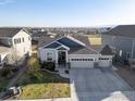 Aerial view of home with large driveway and landscaping surrounded by a suburban neighborhood with mountain views at 675 Lene Ln, Berthoud, CO 80513