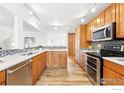 Modern kitchen with stainless steel appliances, granite countertops, and hardwood floors at 803 Ithaca Dr, Boulder, CO 80305