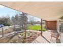 Inviting covered front porch with wooden deck, seating and beautiful landscaping around the entrance at 803 Laurel Ave, Boulder, CO 80303