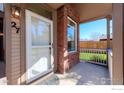 A close-up of the cozy front porch, showcasing brick detail and a secure storm door at 835 Kane Dr # 27, Longmont, CO 80501