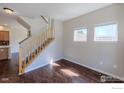 Bright living room with hardwood floors, staircase, and natural light from dual windows at 835 Kane Dr # 27, Longmont, CO 80501