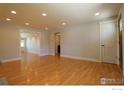 Spacious living area featuring hardwood floors, neutral walls, and an open doorway to another room at 845 10Th St, Berthoud, CO 80513