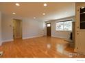 Bright living room featuring hardwood floors, a stone fireplace, and a large window at 845 10Th St, Berthoud, CO 80513