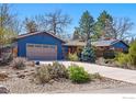 Charming single-story home with blue siding, attached garage, mature trees, and low maintenance landscaping at 10978 W 82Nd Pl, Arvada, CO 80005