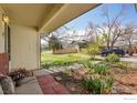 Cozy front porch with brick walkway overlooking a lush lawn and mature landscaping at 1209 Centaur Cir # B, Lafayette, CO 80026